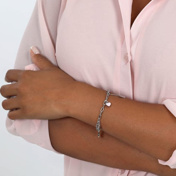 Woman wearing LA PETITE STORY JEWELRY Mod. LPS05ASF56 bracelet in silver with charm, paired with pink blouse.