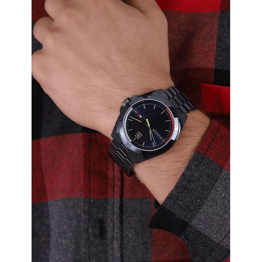 Model wearing TOMMY HILFIGER Mod. 1791689 quartz analog watch, 44 mm case, water resistant to 5 ATM, with mineral dial and bracelet.