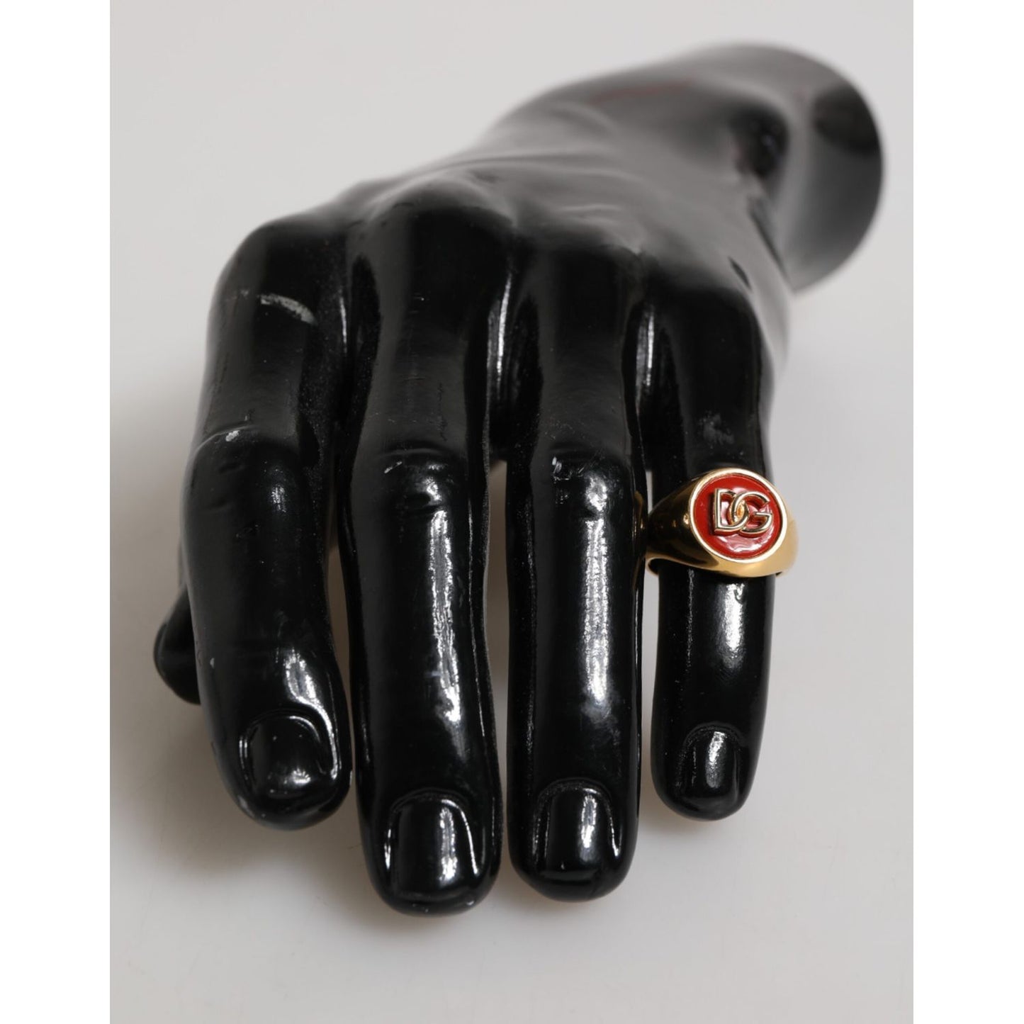 Dolce & Gabbana Gold Tone Real Brass Round Red DG Logo Men Ring displayed on black mannequin hand.