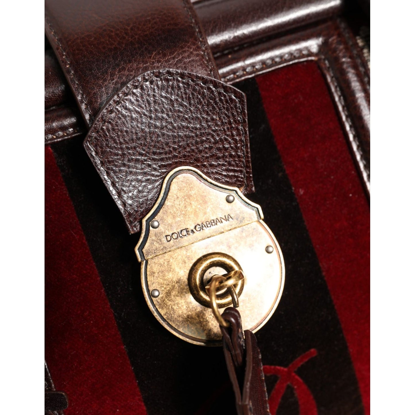 Close-up of Dolce & Gabbana Multicolor Leather Jacquard Velvet Travel Duffle Bag with logo engraved metal hardware and turn-lock closure.