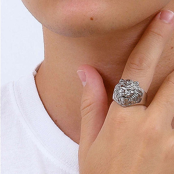 Person wearing a lion's head ring in silver.