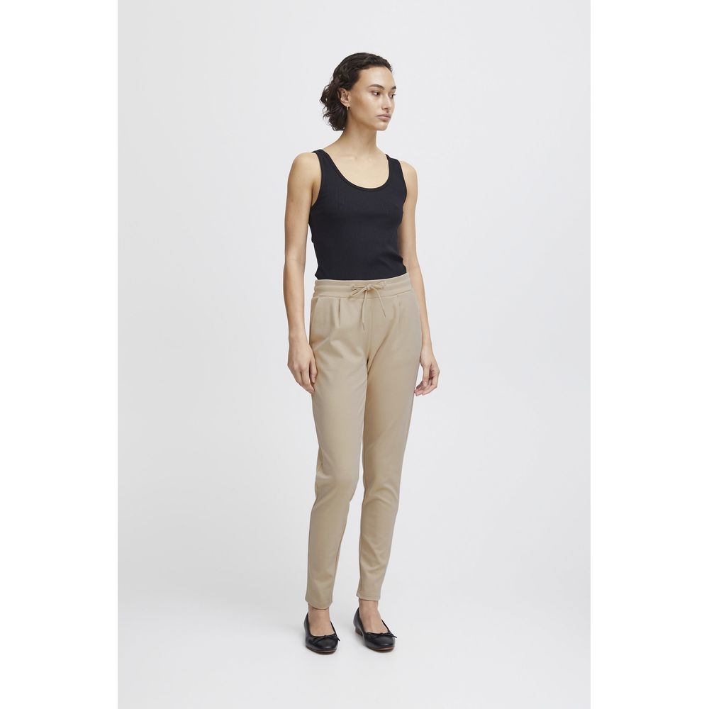 Woman wearing ICHI Beige Polyester Pant with a black top, showcasing slim fit design and elastic waistband.