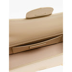 Interior view of Jacquemus Le Grand Bambino Beige Bag showing card pocket and magnetic flap closure with gold logo detail.