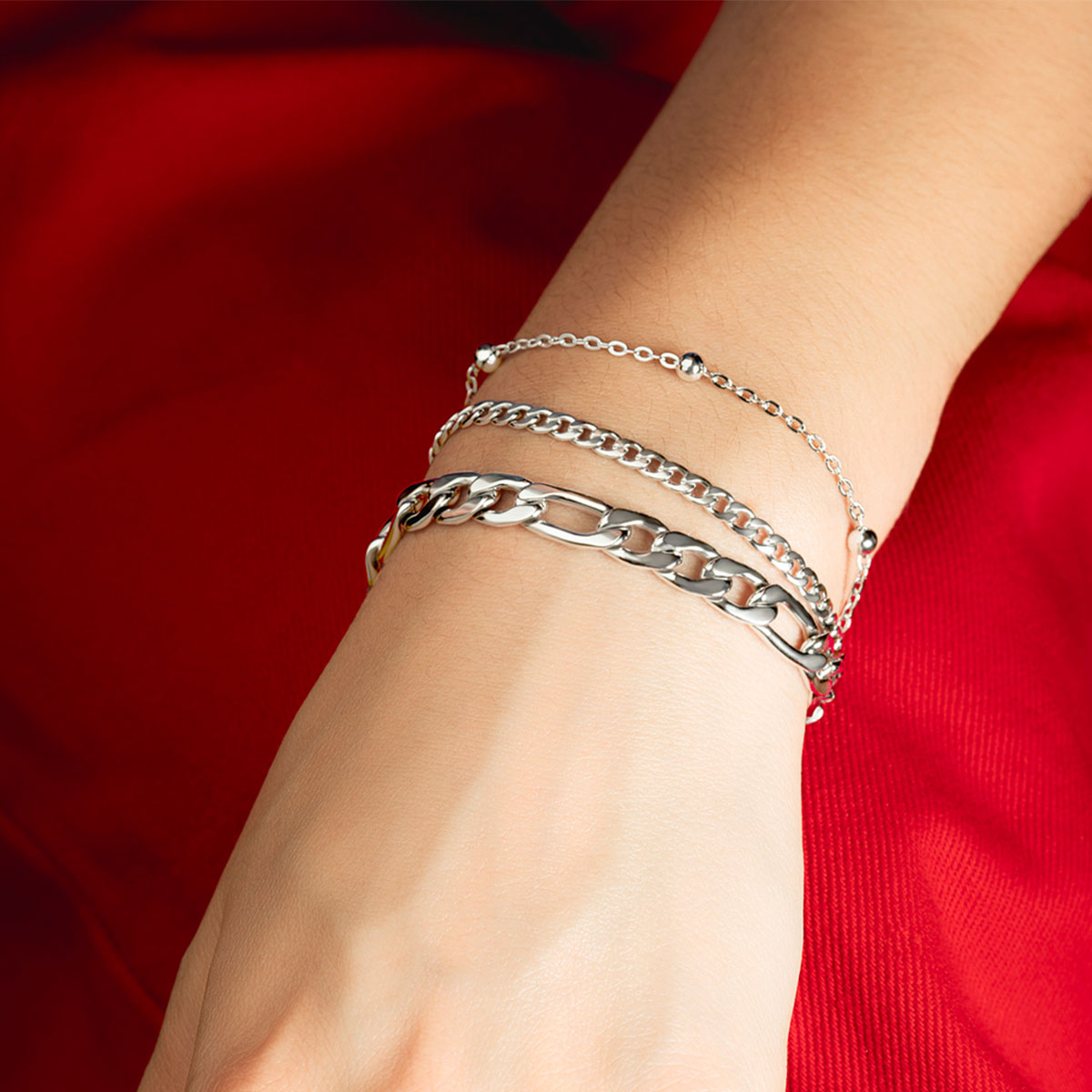 Elegant woman wearing LOTUS JEWELS JEWELRY Mod. LS2339-2/1 bracelet, showcasing intricate silver chain design on her wrist.