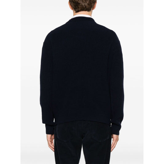 Back view of a person wearing Maison Kitsuné MAISON KITSUNE' Sweaters Blue, featuring oxford blue fisherman's knit and ribbed trim.