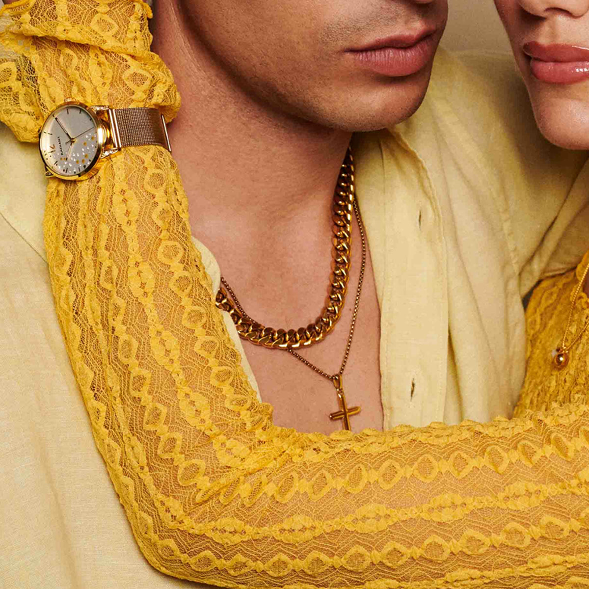 Elegant couple adorned with a gold necklace and watch, showcasing luxurious fashion accessories and style.