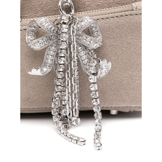 Close-up of silver-tone bow detailing on Self-Portrait suede baguette shoulder bag with grey suede, showcasing luxurious style.