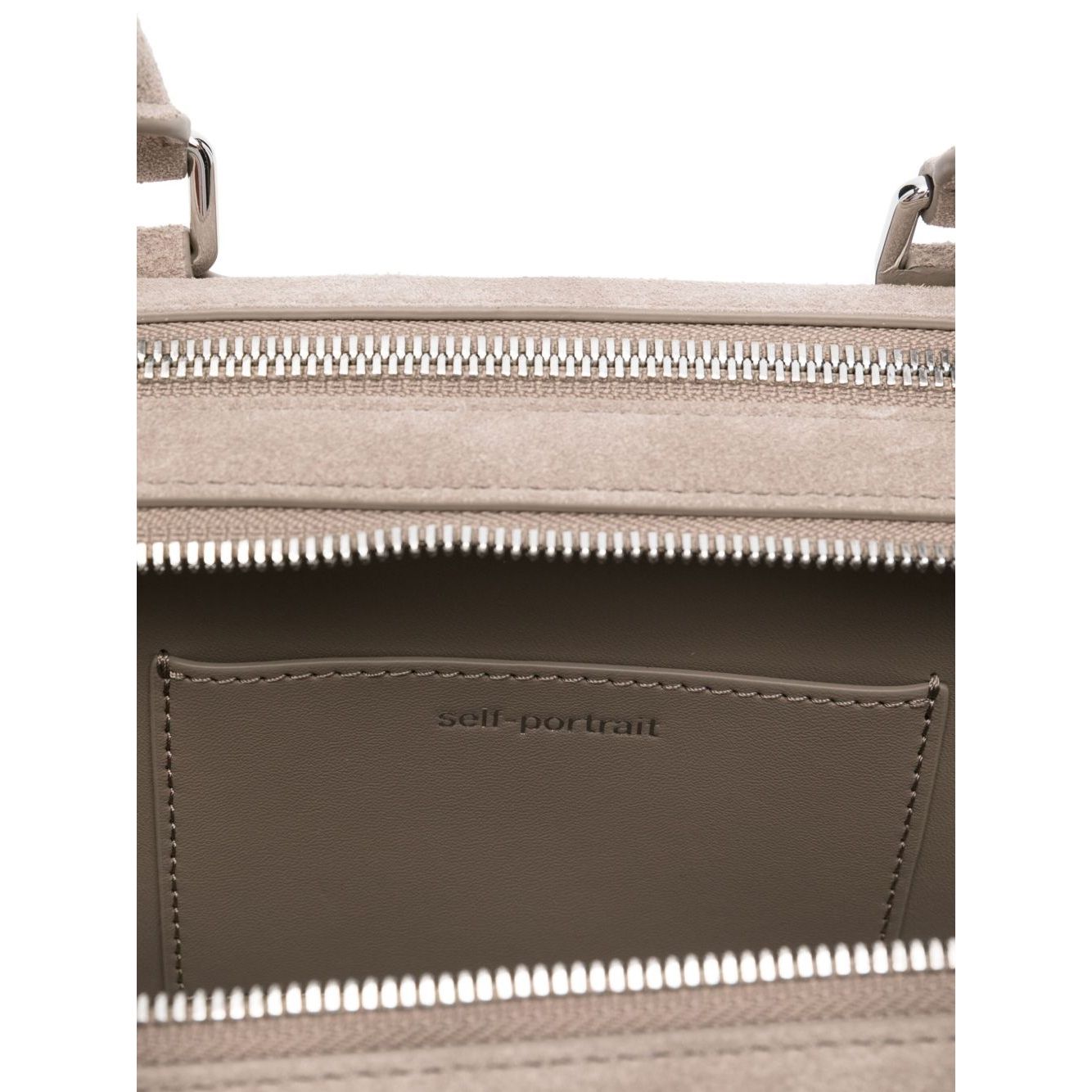 Interior view of Self-Portrait suede baguette shoulder bag showing top zip and slip pocket with silver-tone hardware.