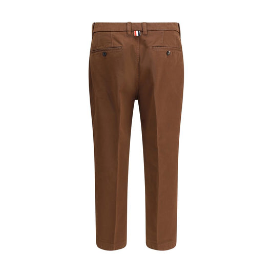 Thom Browne Cotton Pants, beige straight-leg with tricolor patch, showing back view and buttoned welt pockets.